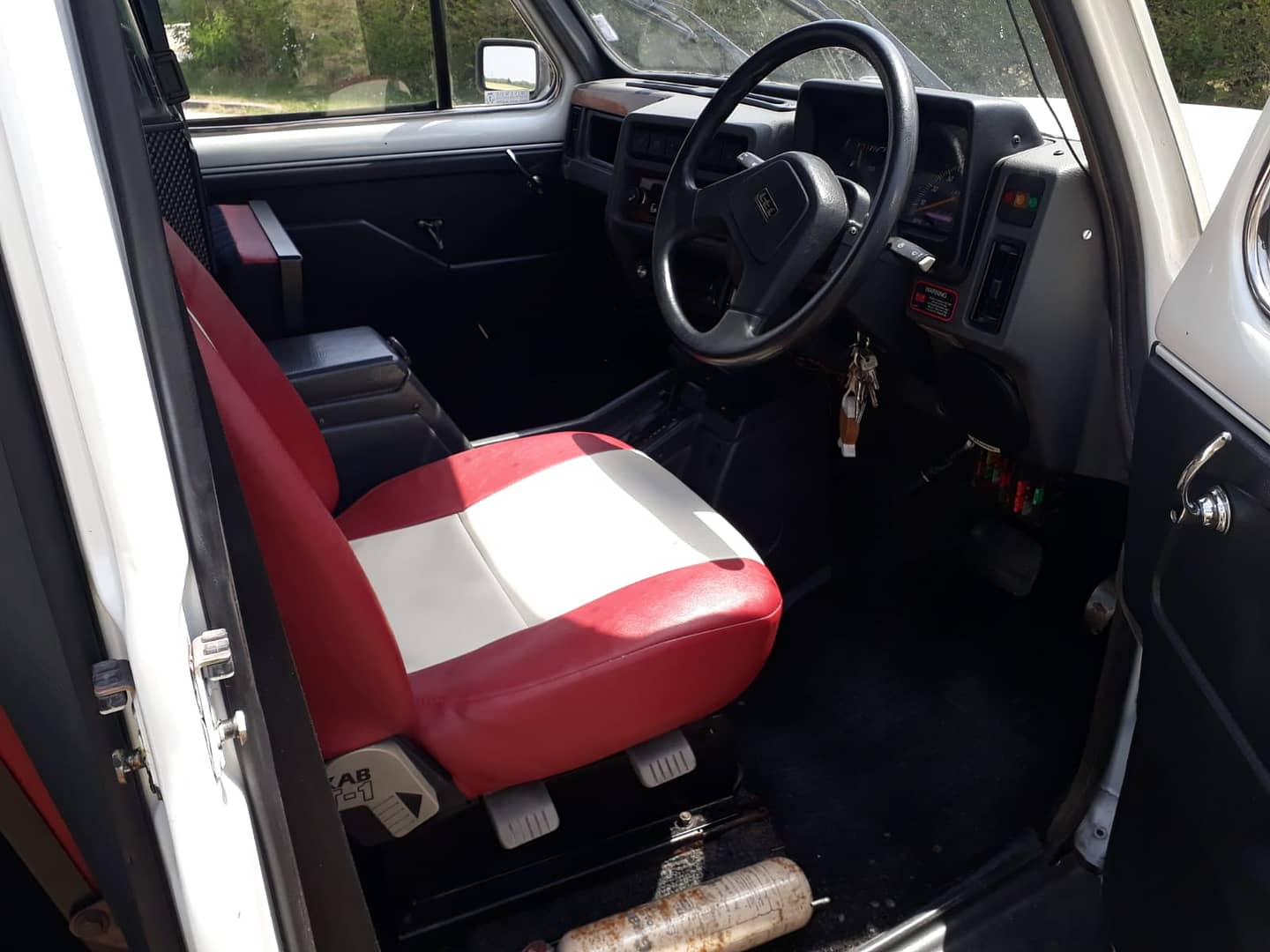 siege conducteur en vinyl rouge et blanc dans taxi anglais