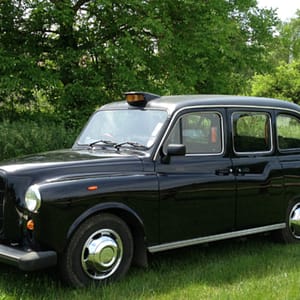 taxi anglais noir sur herbe prise de vue en trois quart avant gauche