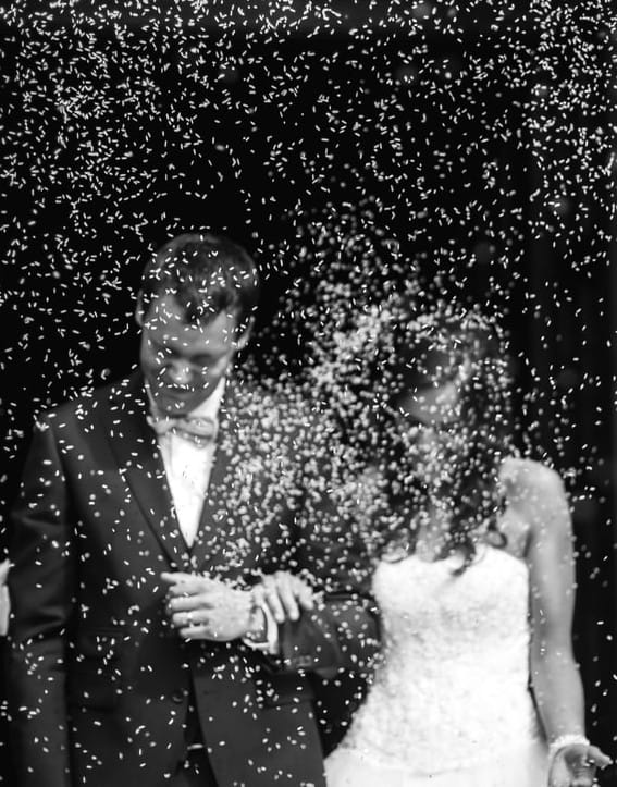 les maries avancent dans une nuee de confettis symbolisants l'incertaine vision de l'avenir du mariage face au coronavirus