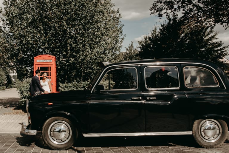 taxi anglais noir devant cabine telephonique rouge et les maries